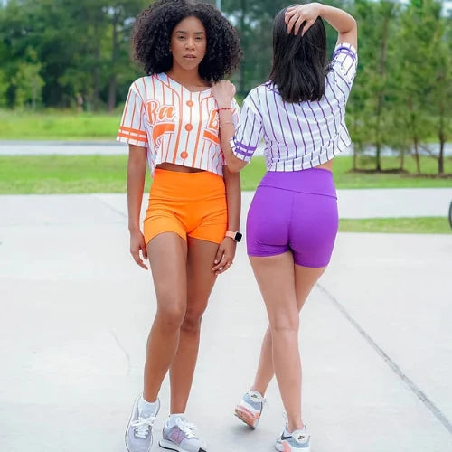 Two women wearing purple and orange activewear sets from the 'Shorts + Top Activewear Set (2 Piece) collection