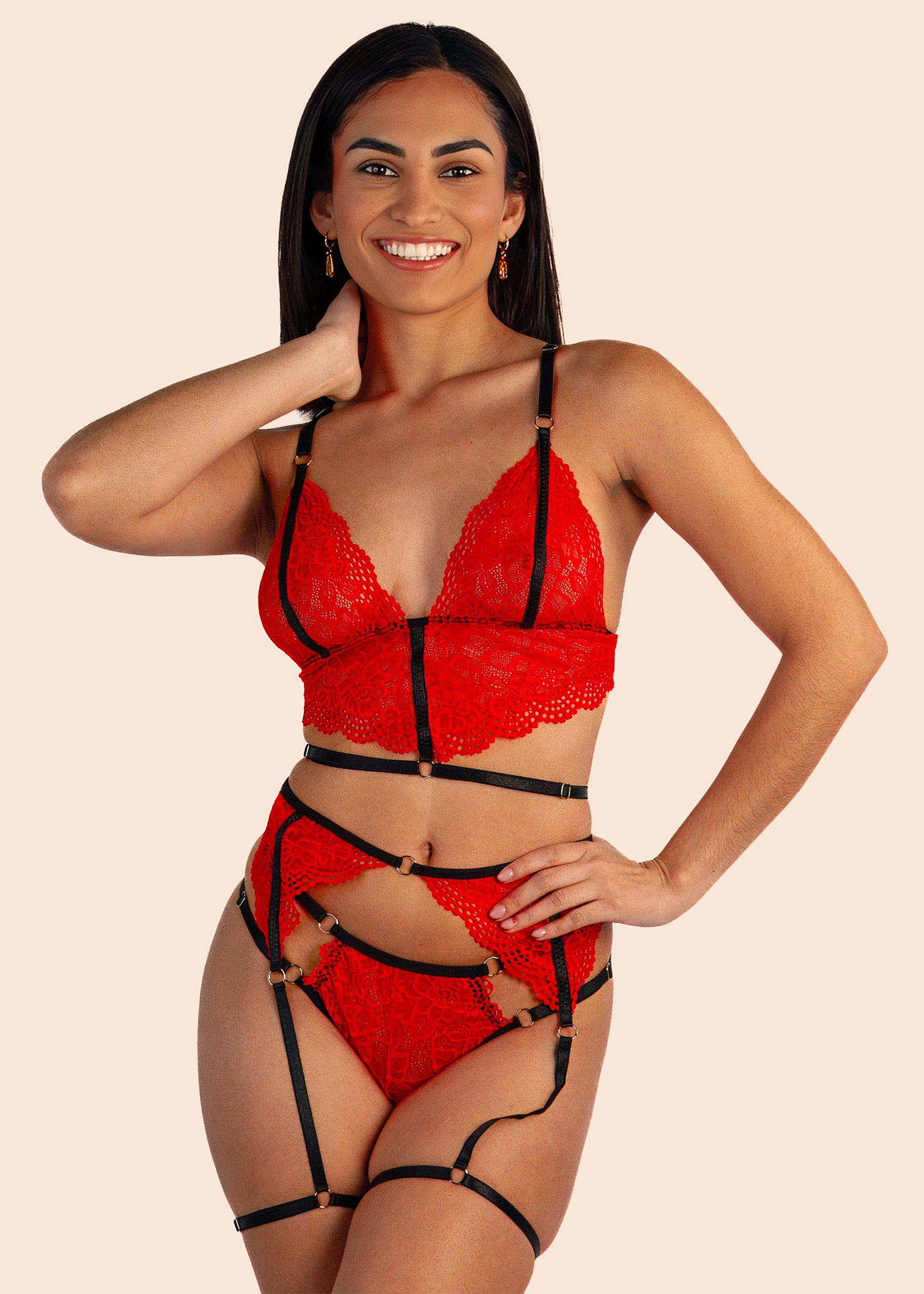 Woman wearing a red lace lingerie set with black straps on a beige background