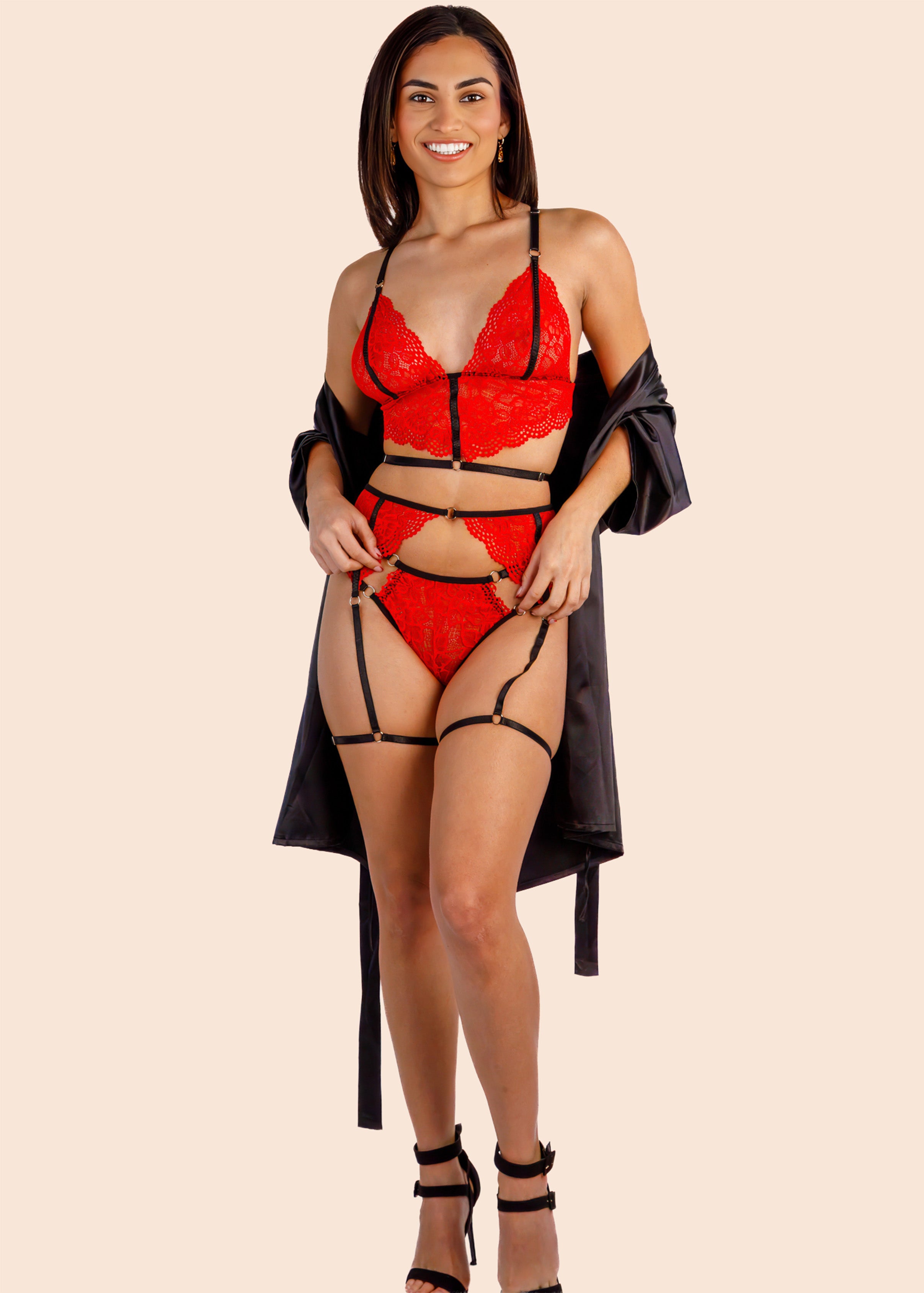 Woman wearing a red lingerie set with black strappy details on a beige background