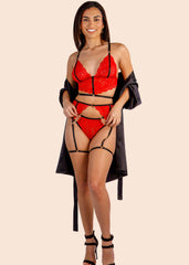 Woman wearing a red lingerie set with black strappy details on a beige background