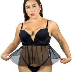 Woman wearing a black lingerie set with sheer overlay on a white background