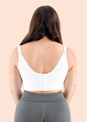 Person wearing a white sports bra and gray leggings on a beige background