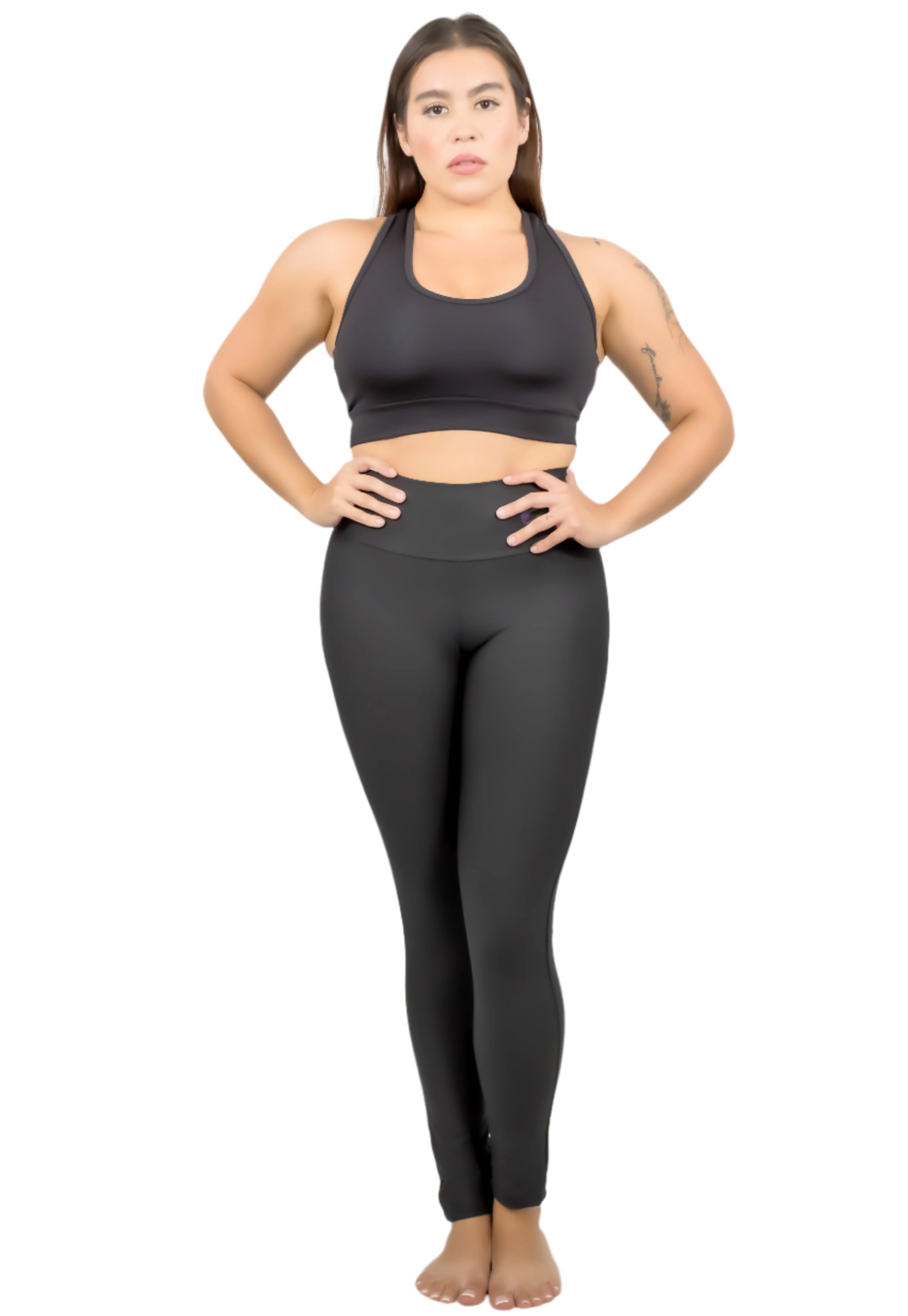 Woman wearing a black sports bra and leggings on a white background
