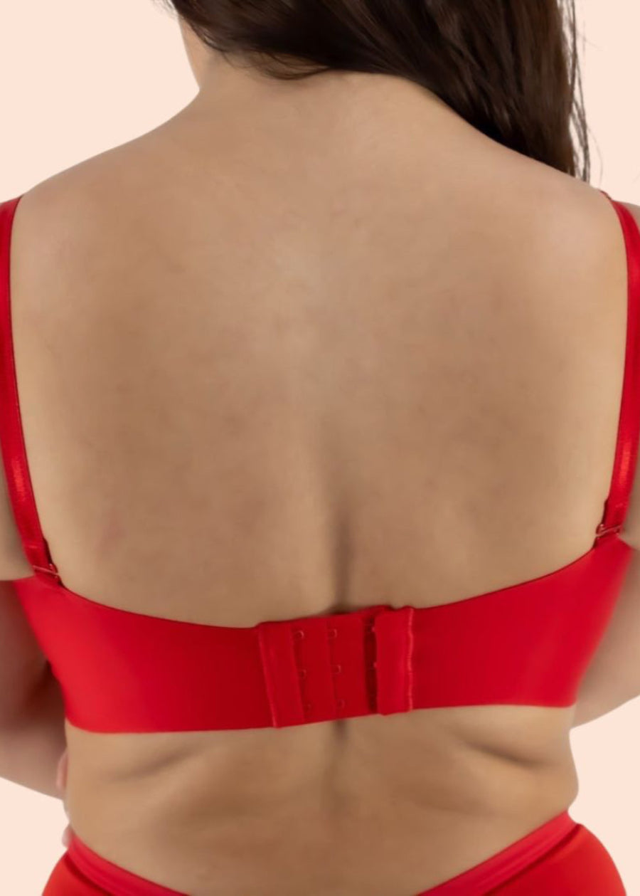 Red bikini top worn by a person on a beige background