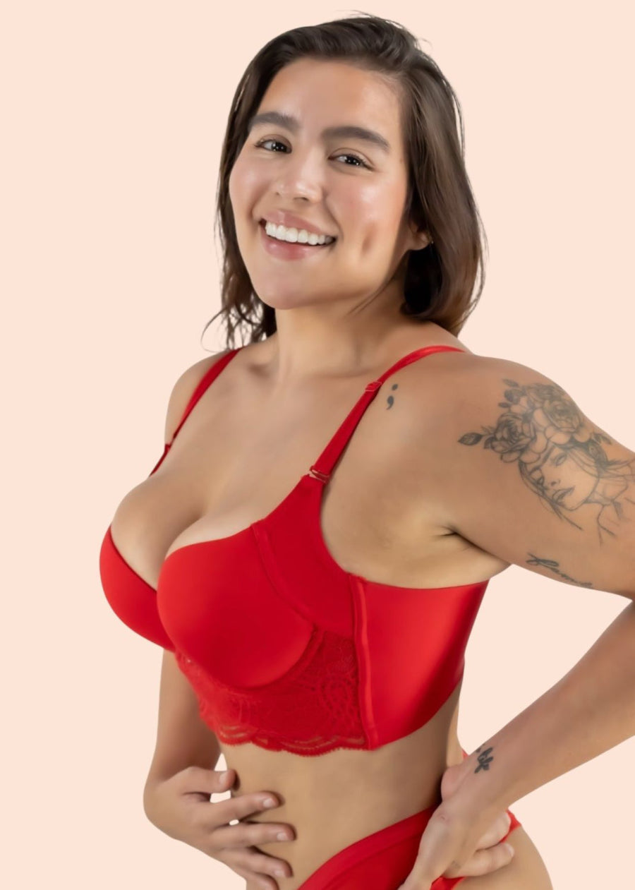 Woman wearing a red bra and panties set on a beige background