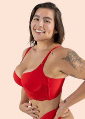 Woman wearing a red bra and panties set on a beige background