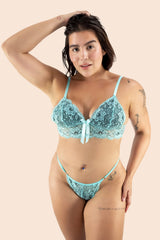 Woman wearing a light blue lace bra and panties set on a beige background