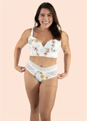 Woman wearing a floral white bra and panties set on a beige background