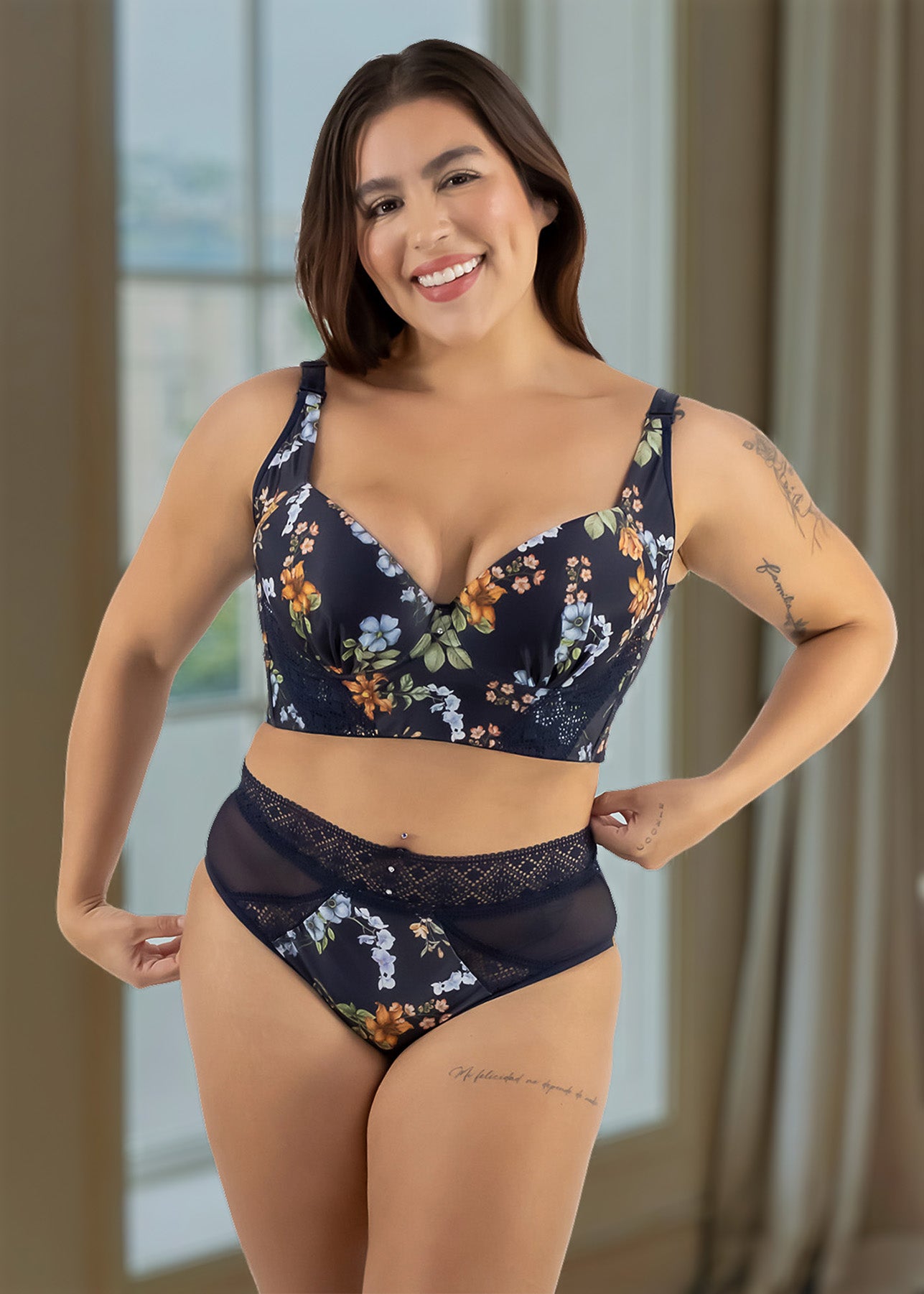 Woman wearing a navy floral lingerie set in a well-lit room.