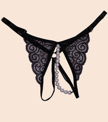 Black lace lingerie with pearl accents on a beige background