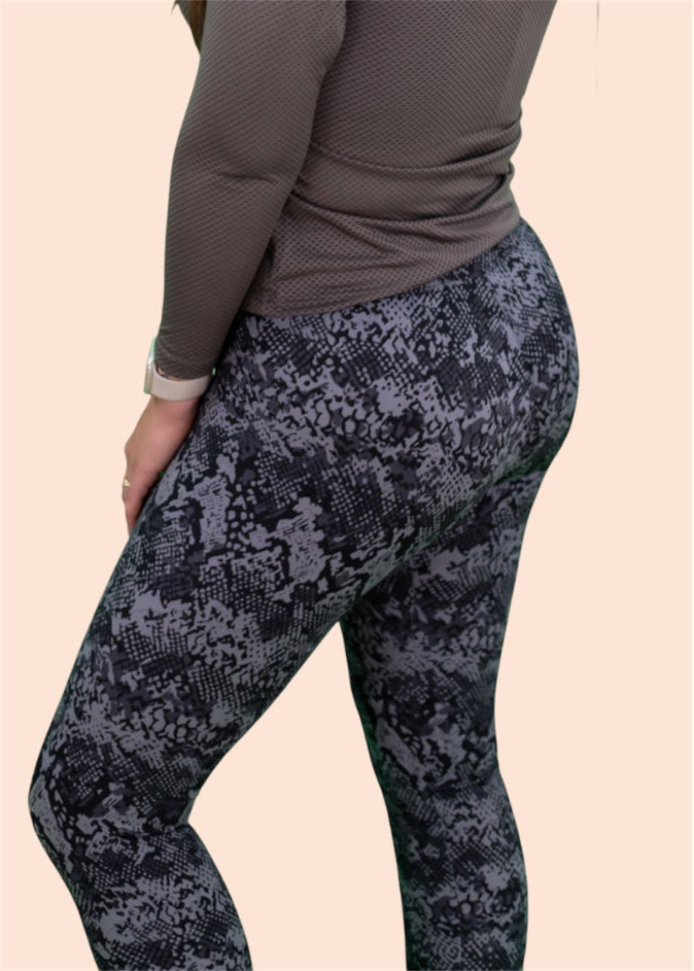 Person wearing dark patterned leggings on a beige background