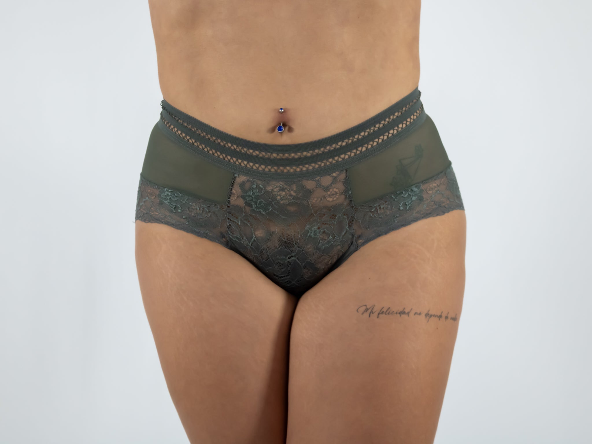 Green lace underwear worn by a person on a white background