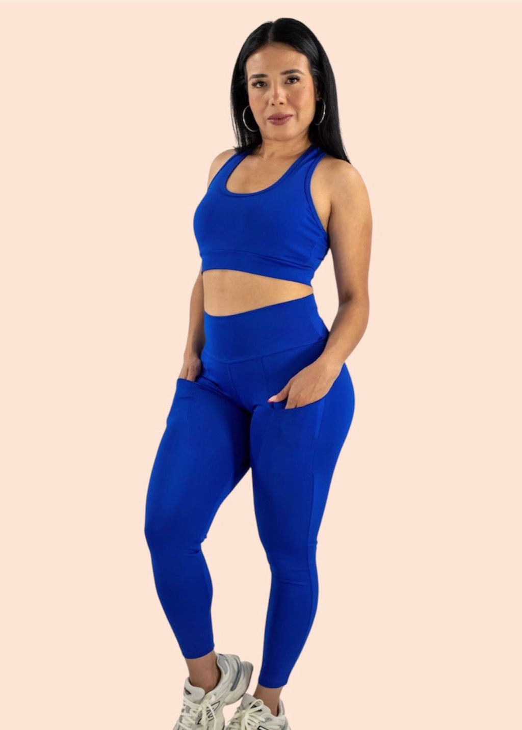 Woman wearing a blue athletic outfit on a beige background