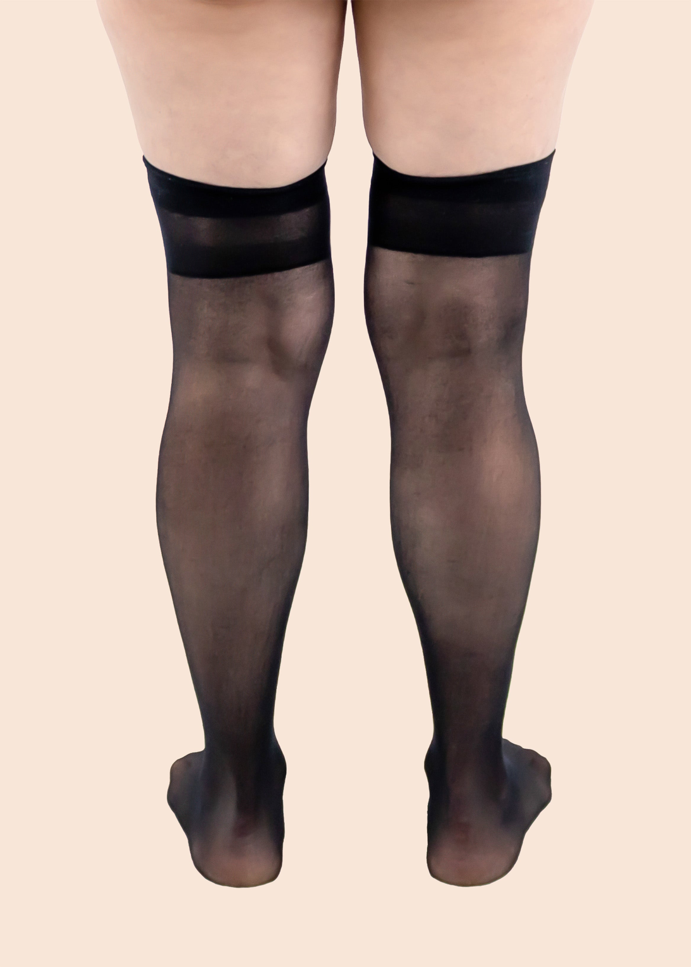 Black sheer tights worn by a person on a beige background
