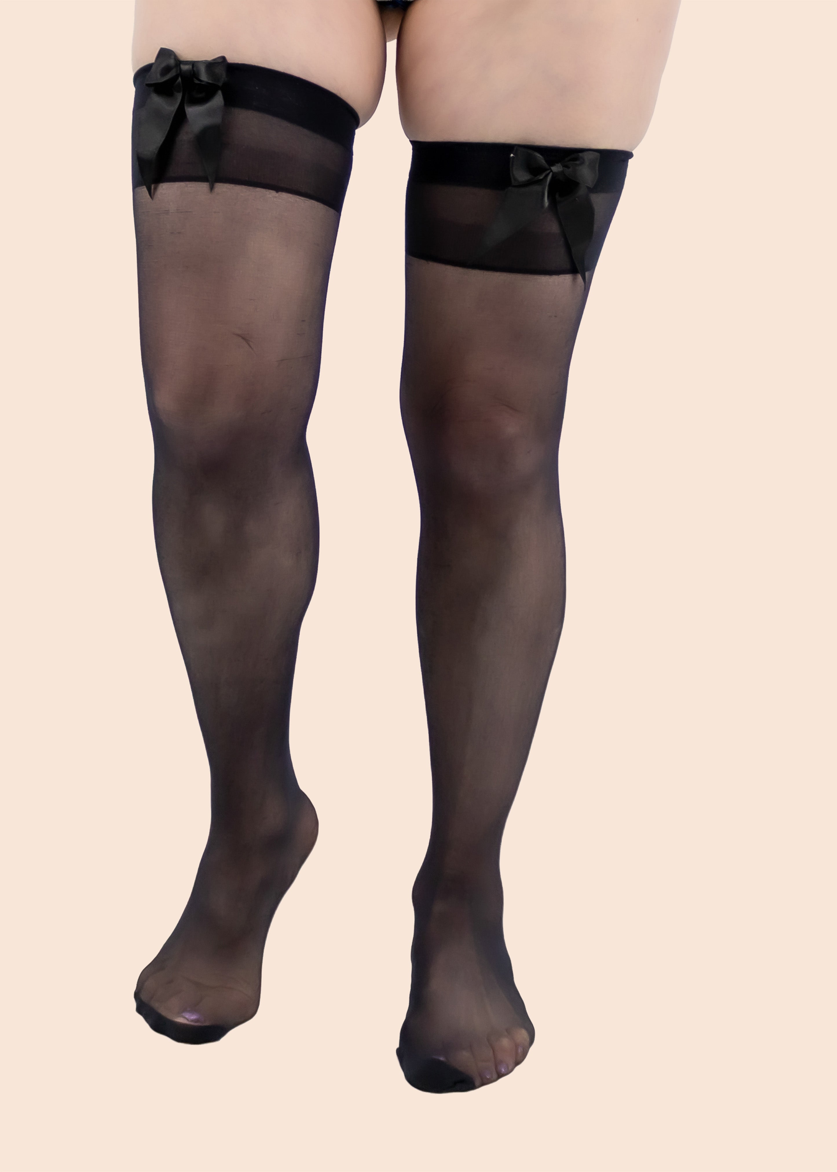 Black sheer stockings with bow details on a beige background