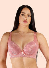 Woman wearing a pink lace bra against a beige background