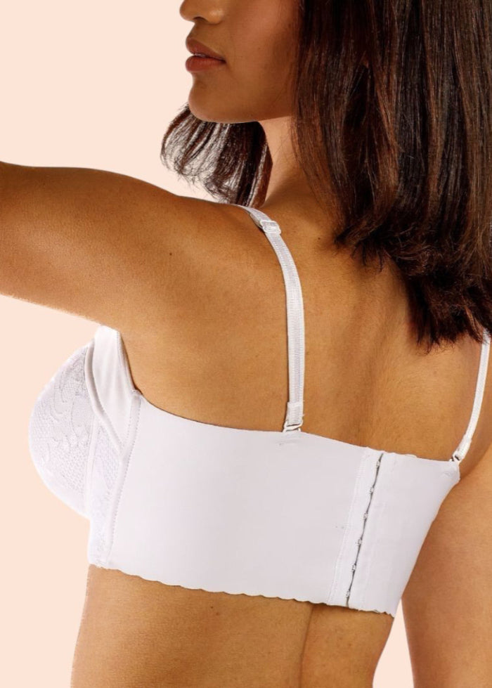 Woman wearing a white compression garment against a beige background