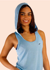 Woman wearing a blue athletic outfit with a hood on a beige background