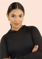 Woman wearing a black long-sleeve top against a light pink background
