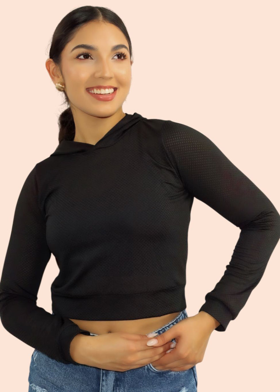 Woman wearing a black hoodie with mesh sleeves on a pink background