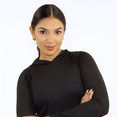 Woman wearing a black long-sleeve top and blue jeans on a white background