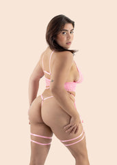 Woman wearing a pink lingerie set on a beige background