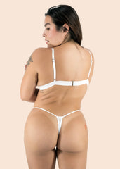 Woman wearing a white bikini on a beige background