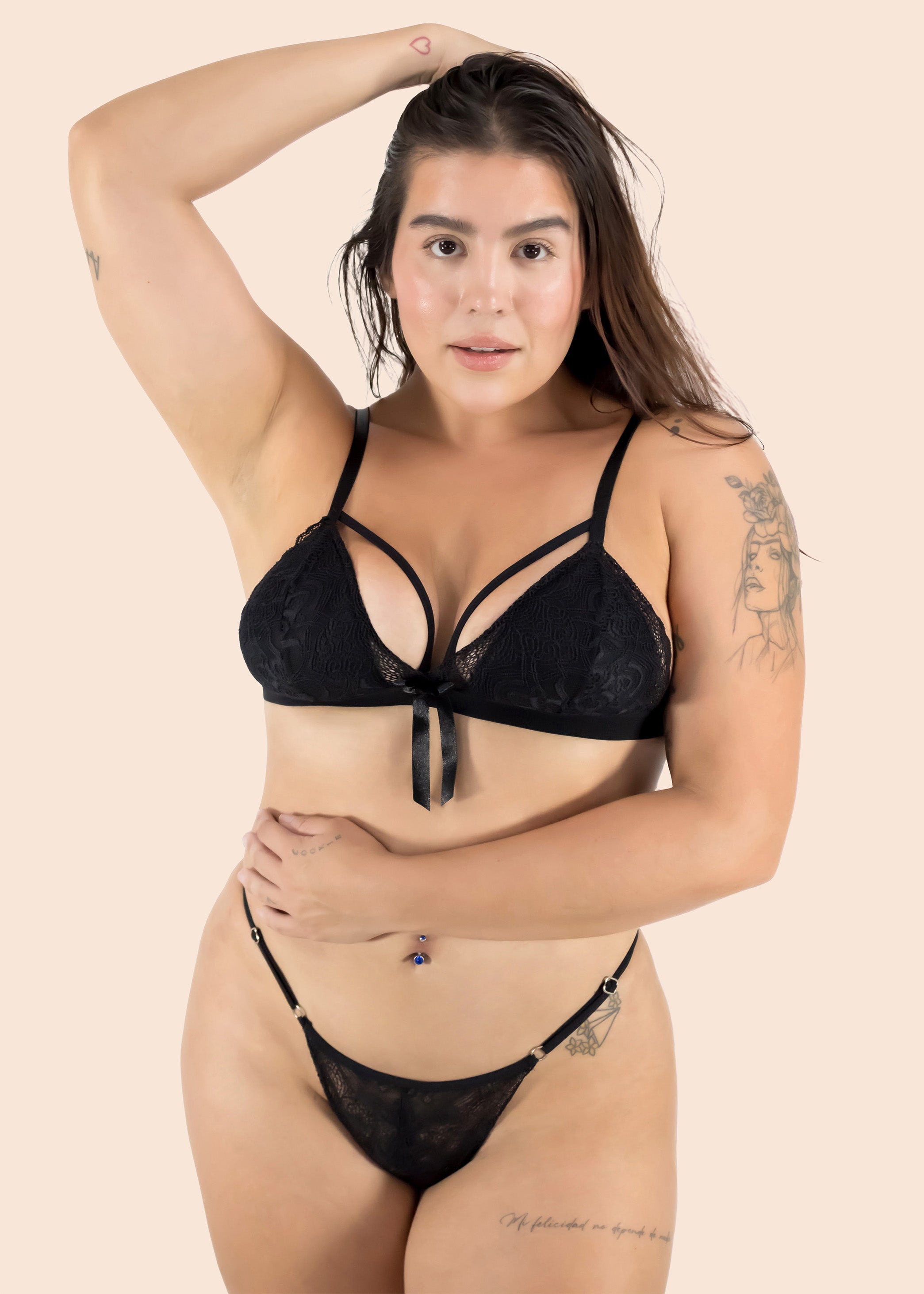 Woman wearing a black lace lingerie set on a beige background