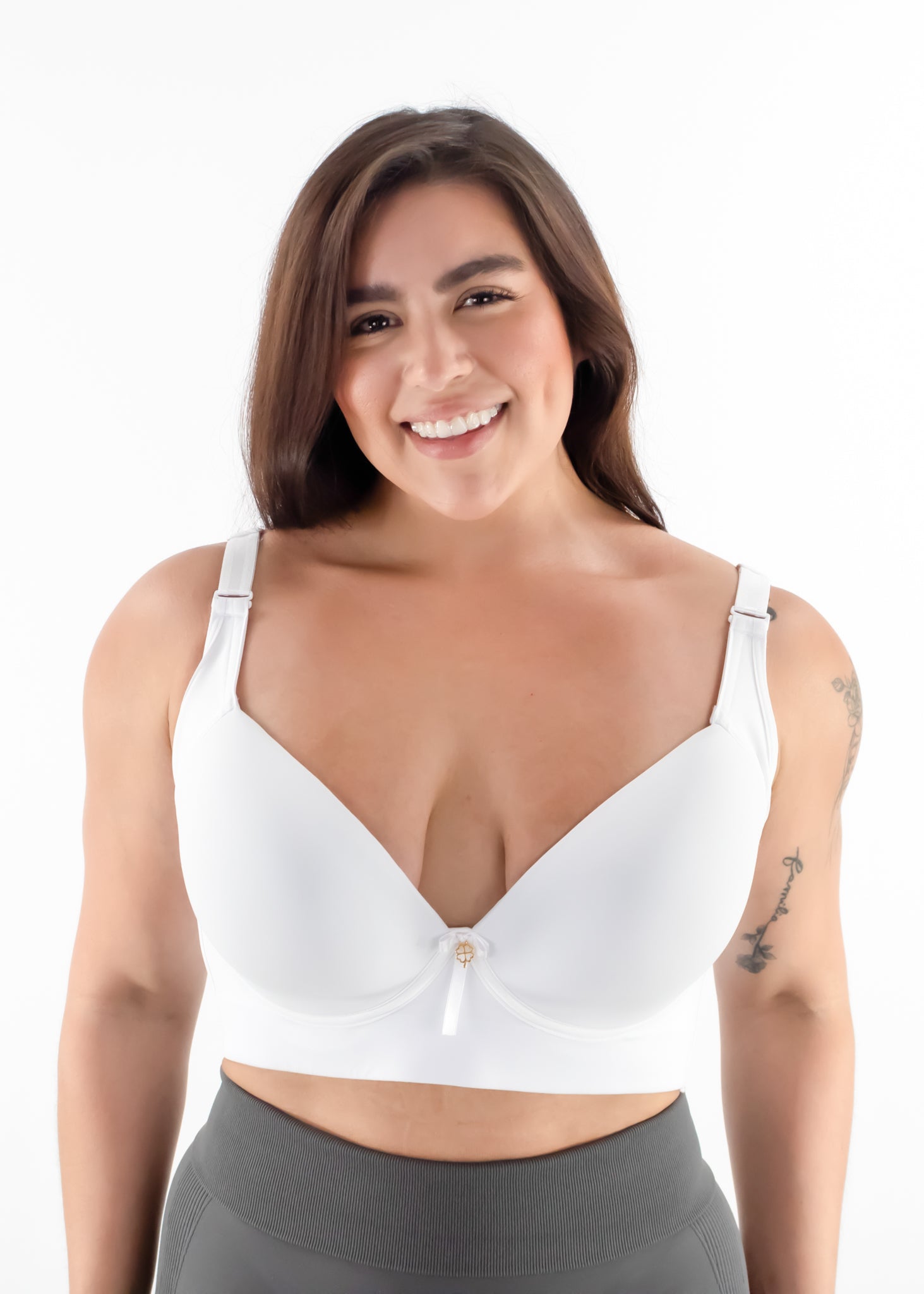 Woman wearing a white bralette with gray leggings on a white background