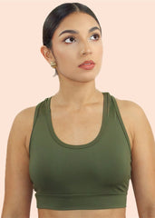 Woman wearing a green sports bra against a beige background