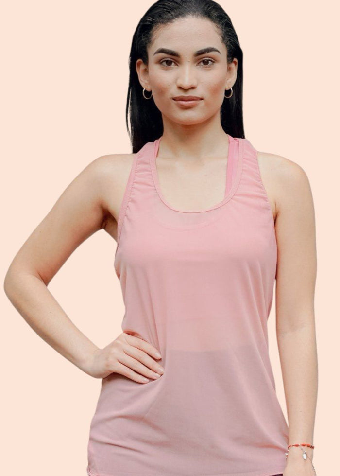 Woman wearing a pink sleeveless top on a light pink background