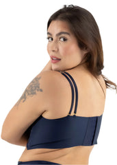 Woman wearing a navy blue bikini top with thin straps on a white background