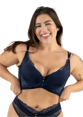 Woman wearing a navy blue lace bra and panties set on a white background