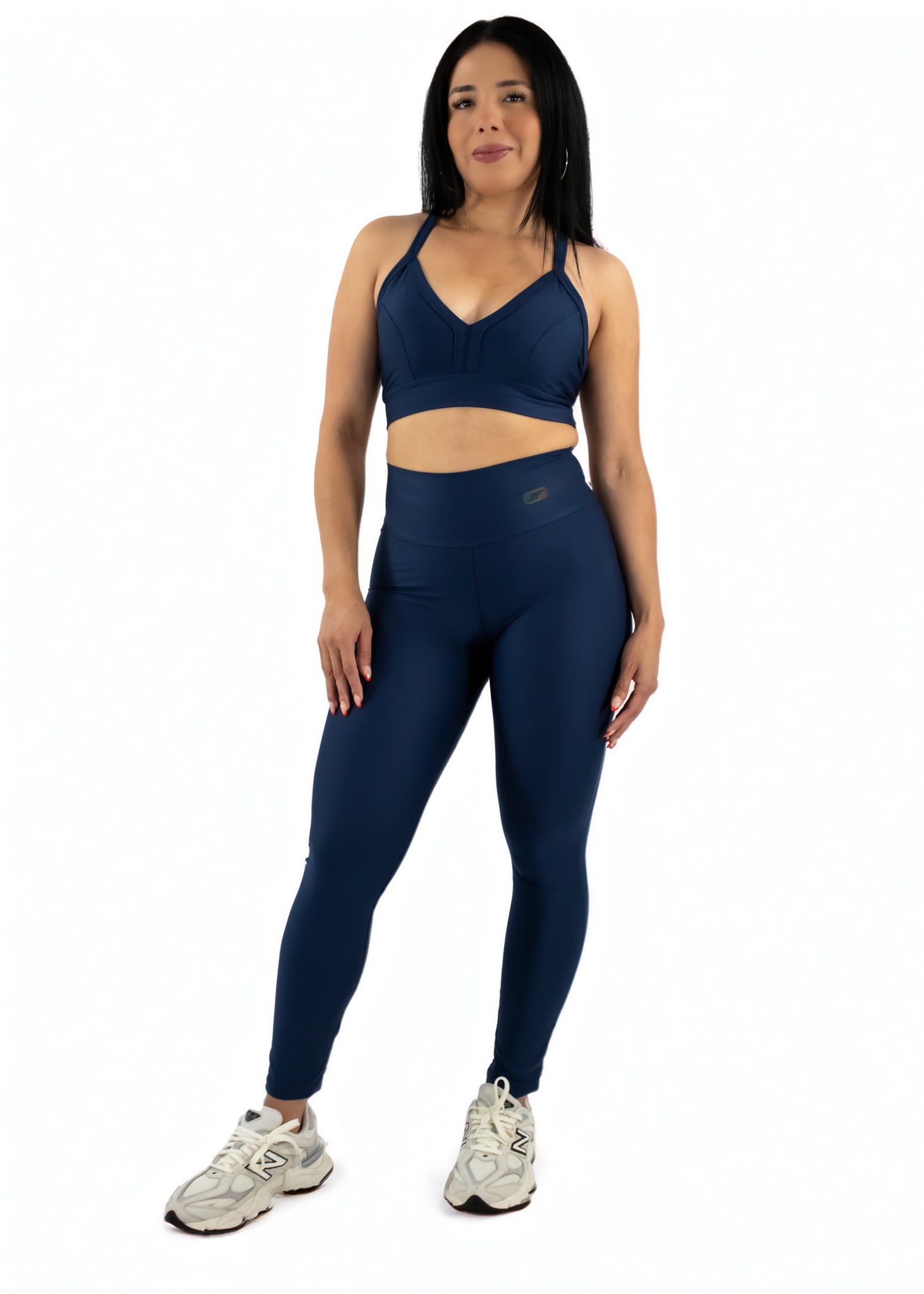 Woman wearing a navy athletic outfit on a white background