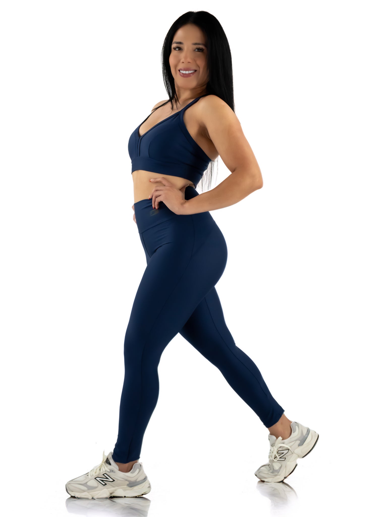 Woman wearing a navy blue athletic outfit on a white background