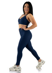 Woman wearing a navy blue athletic outfit on a white background