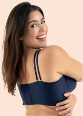Woman wearing a navy blue bralette against a beige background