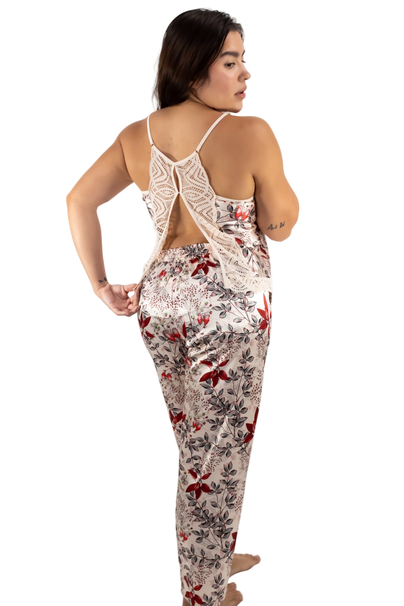 Woman wearing a floral jumpsuit with a lace top on a white background
