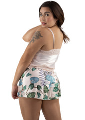 Woman wearing a white top and leaf-patterned skirt on a white background