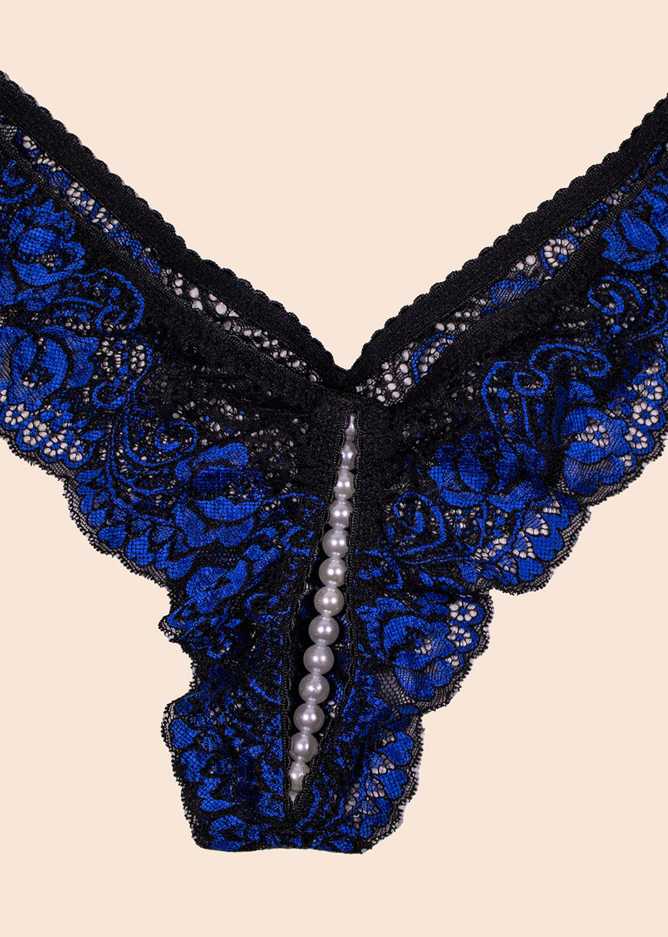 Black lace lingerie with blue floral patterns and pearl accents on a beige background