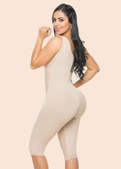 Woman wearing a beige bodysuit against a plain background