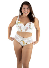 Woman wearing a floral white lingerie set on a plain background