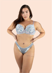 Woman wearing a floral bra and denim underwear set on a beige background