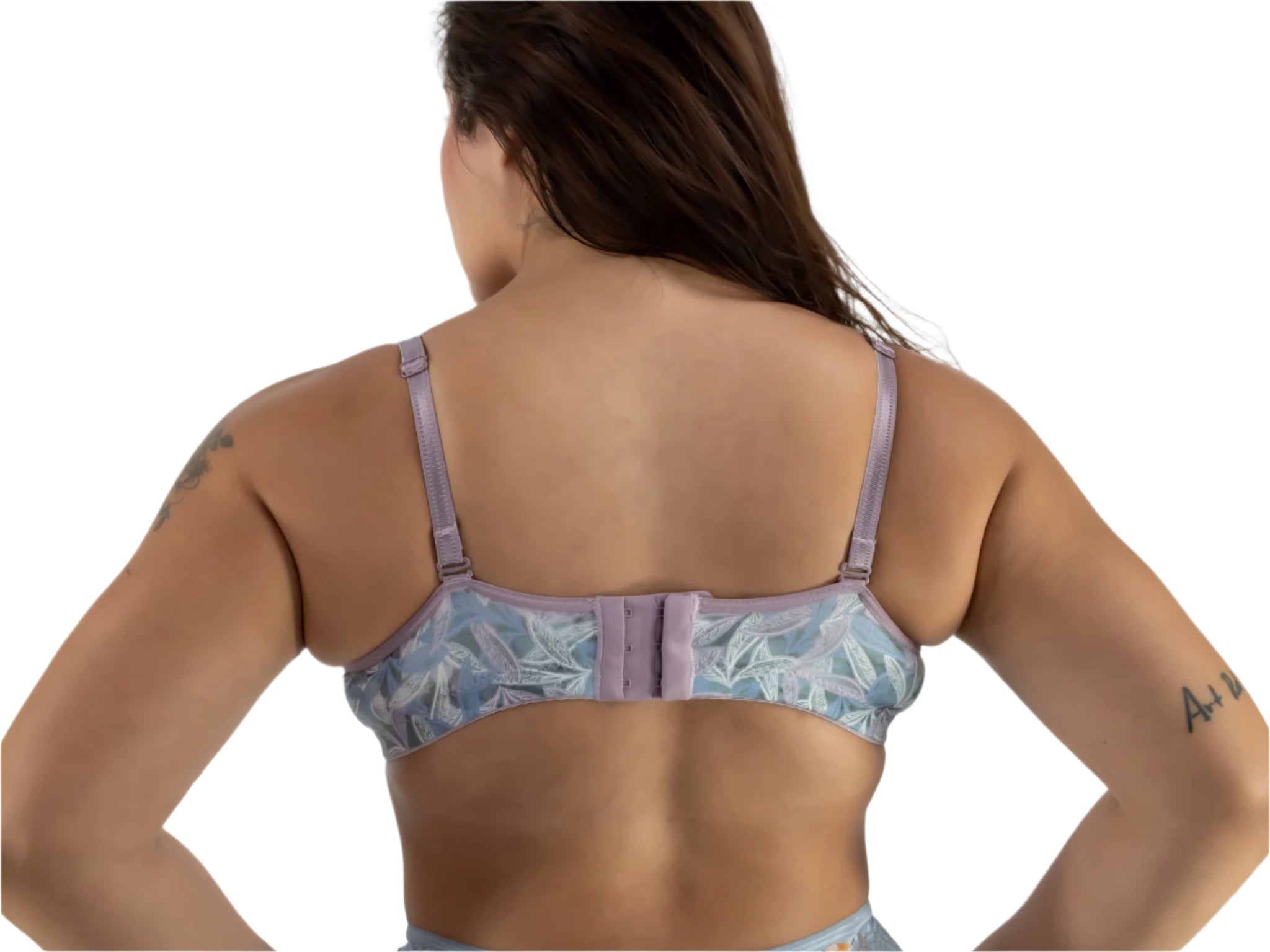 Woman wearing a patterned bralette on a plain background