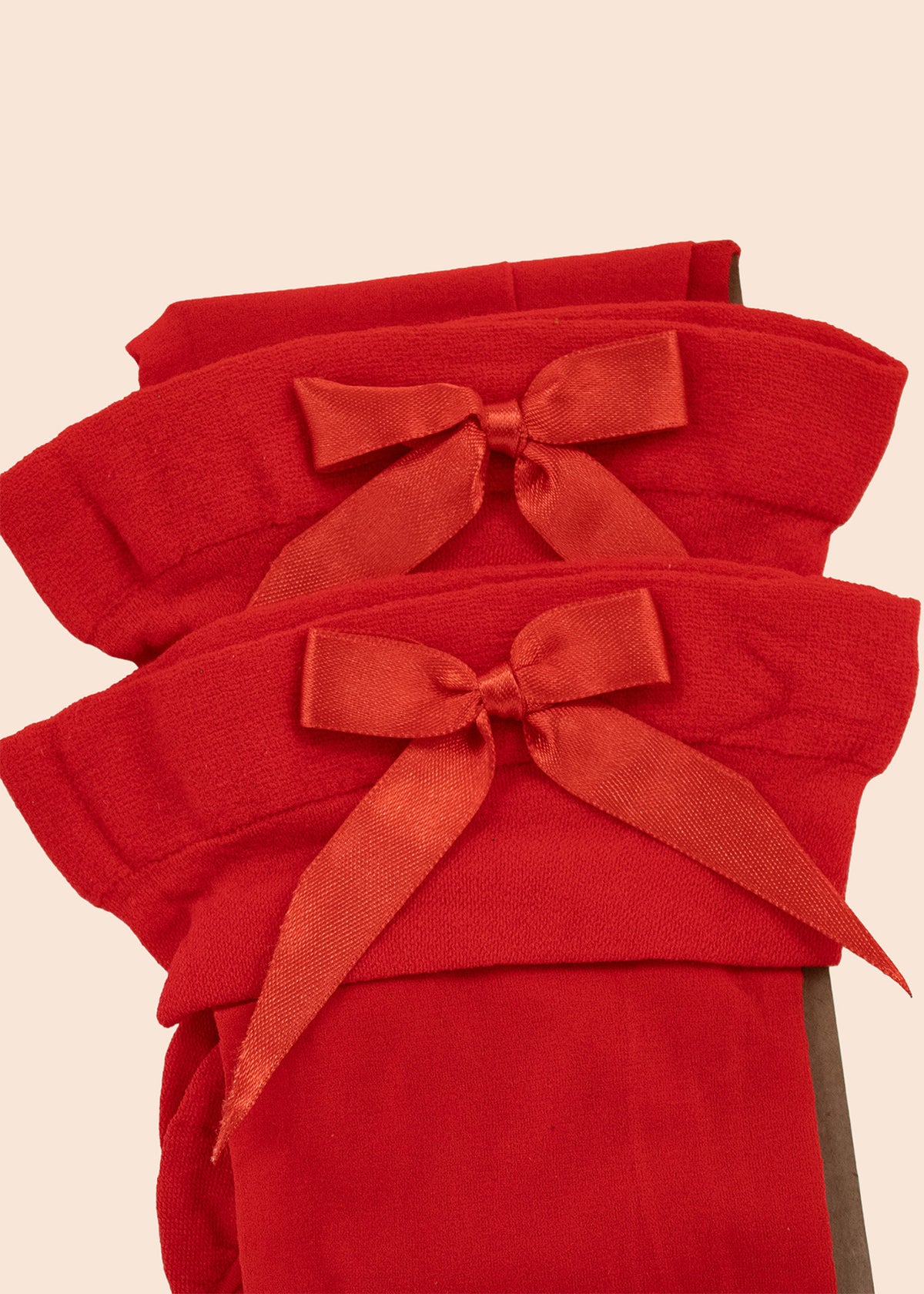 Stack of red cloths with ribbons on a beige background