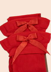 Stack of red cloths with ribbons on a beige background