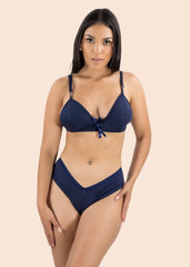Woman wearing a navy blue bikini set on a beige background