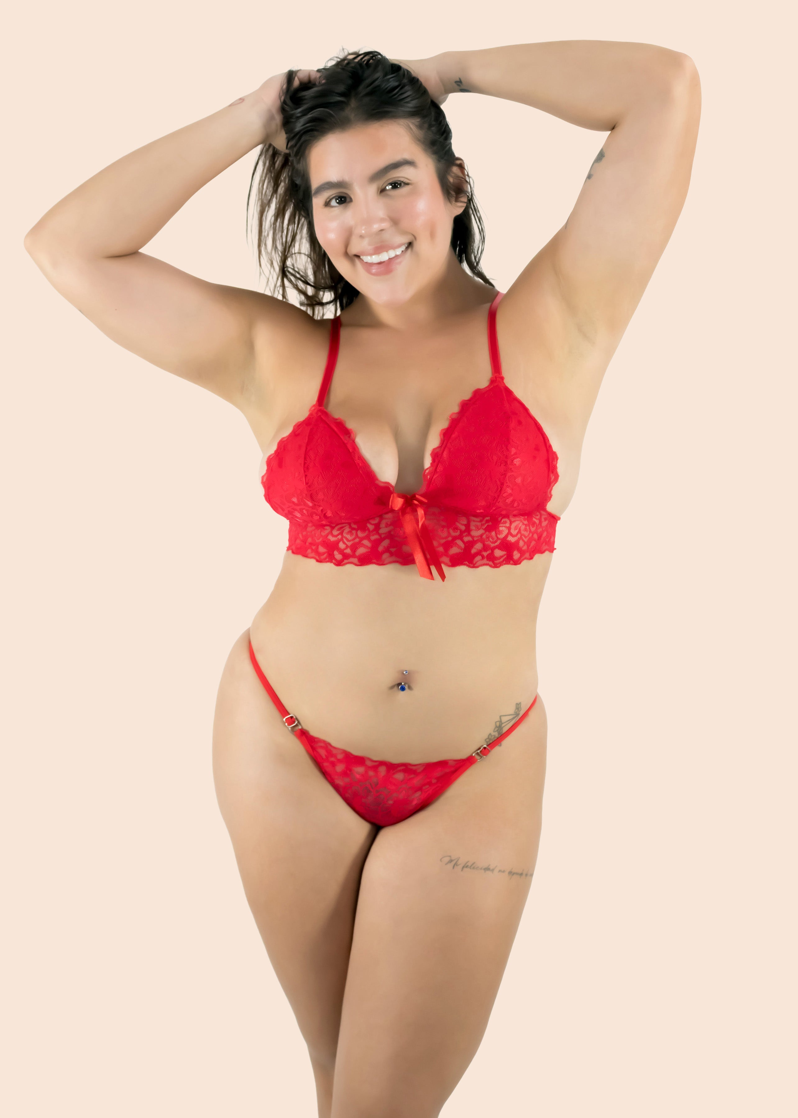 Woman wearing a red lace lingerie set against a beige background