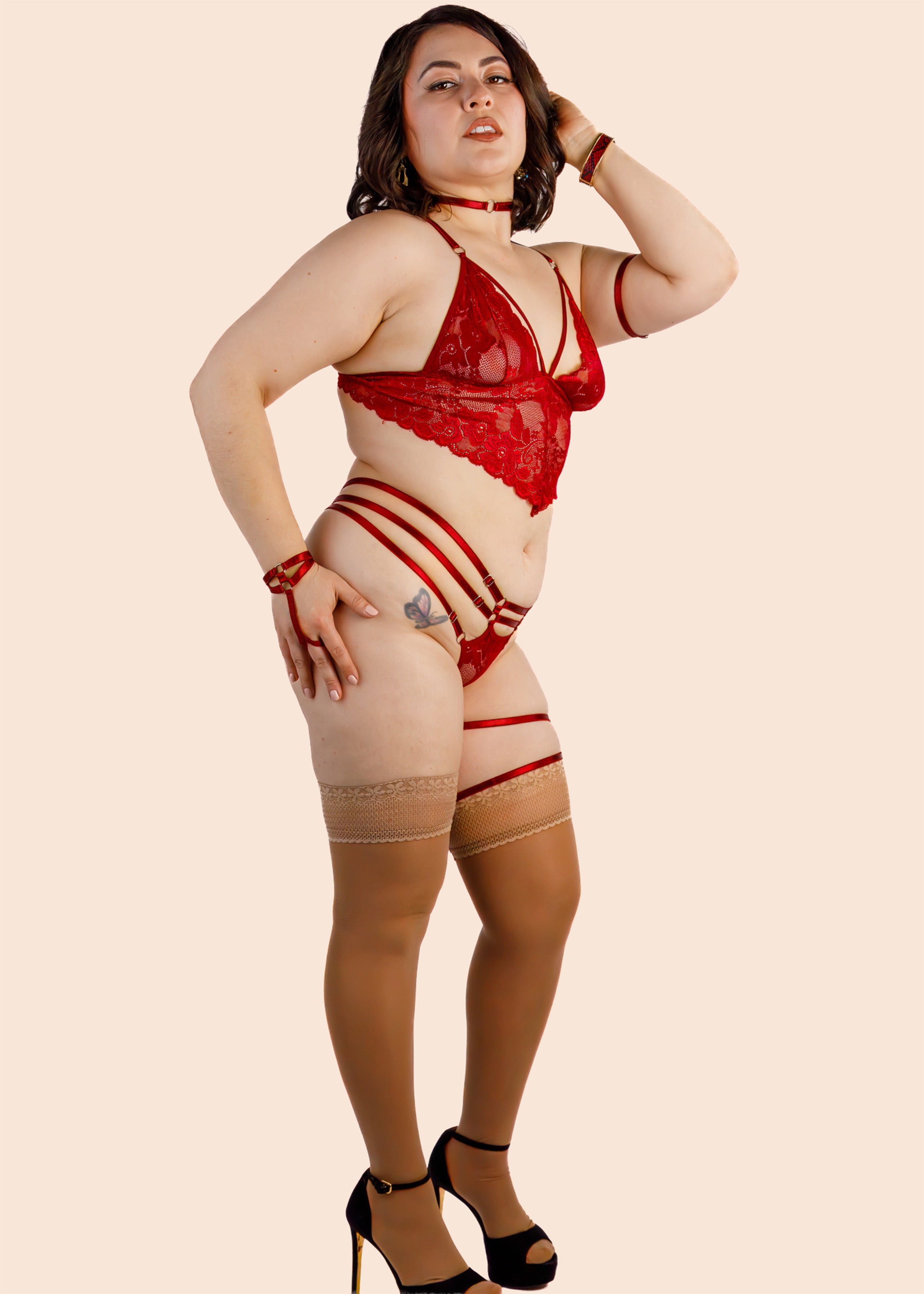 Woman wearing a red lingerie set on a beige background
