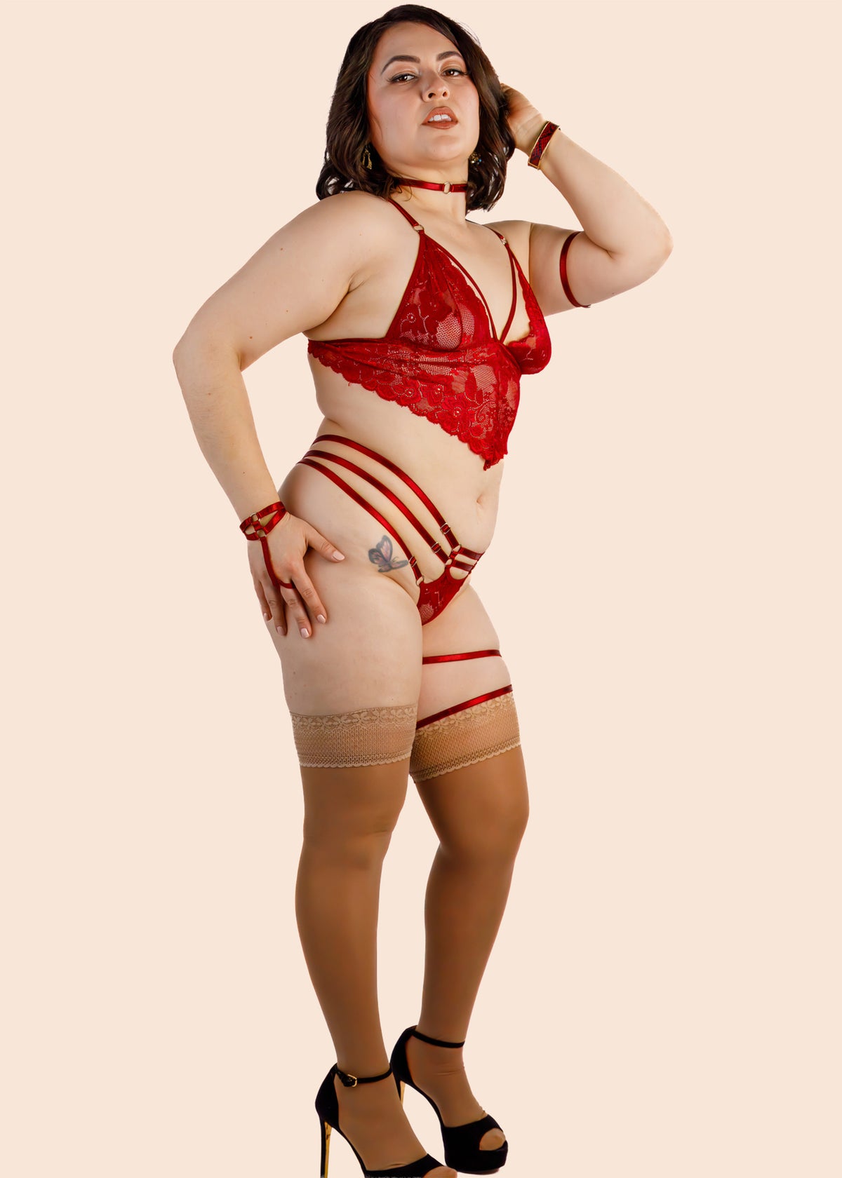 Woman wearing a red lingerie set on a beige background